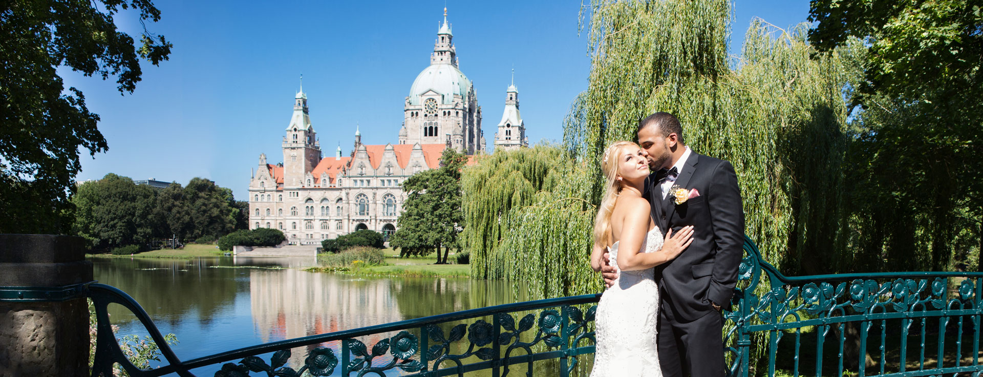 Brautpaar auf der Brücke am Maschpark mit dem Blich auf Maschteich und Hannover Rathaus